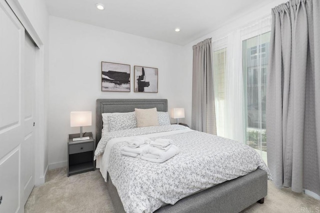 bedroom featuring recessed lighting, baseboards, a closet, and light colored carpet