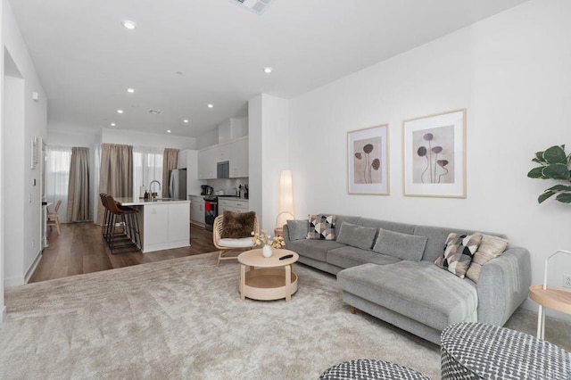 living area with visible vents, wood finished floors, and recessed lighting