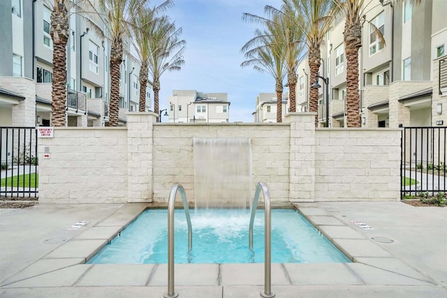 view of swimming pool featuring fence