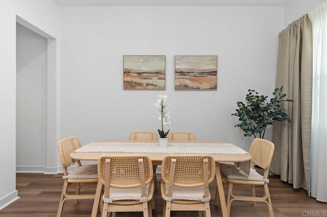 dining area with dark wood finished floors and baseboards