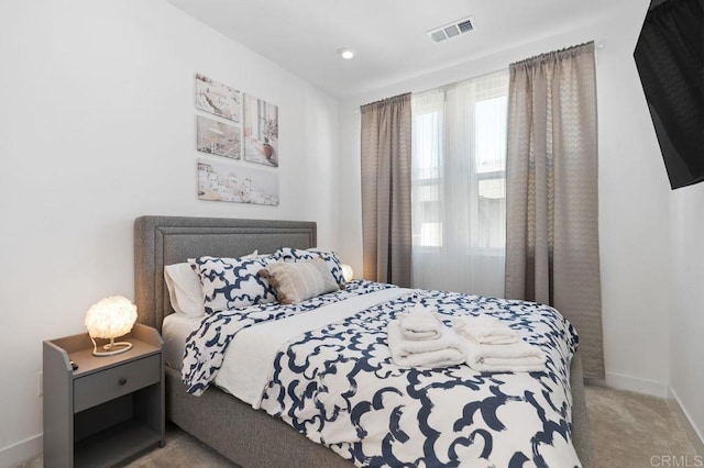 carpeted bedroom with visible vents and baseboards