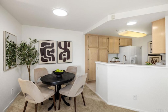 dining room with light carpet and baseboards