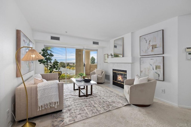 carpeted living room featuring baseboards, a fireplace, and visible vents