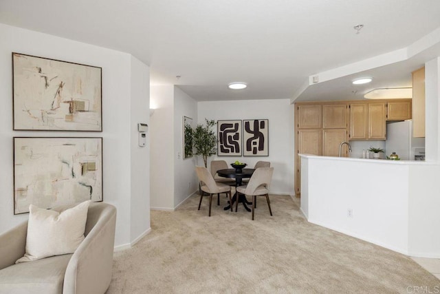 dining area featuring baseboards and light colored carpet