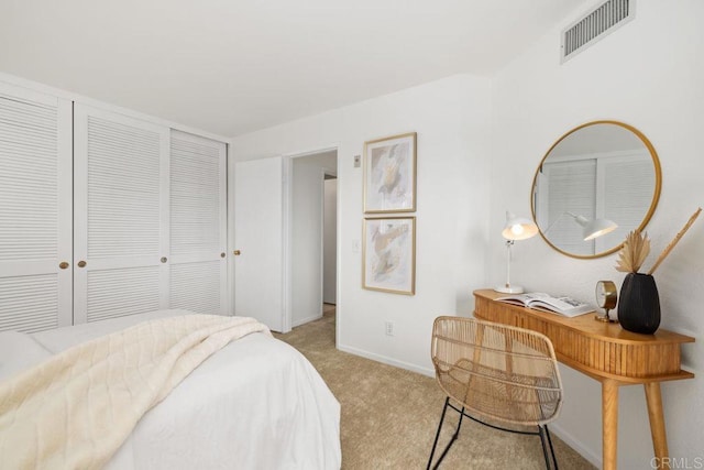 bedroom with a closet, visible vents, light carpet, and baseboards