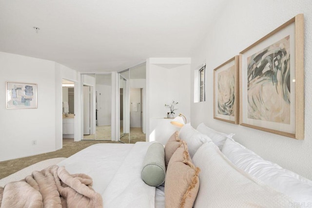 bedroom featuring light colored carpet and connected bathroom