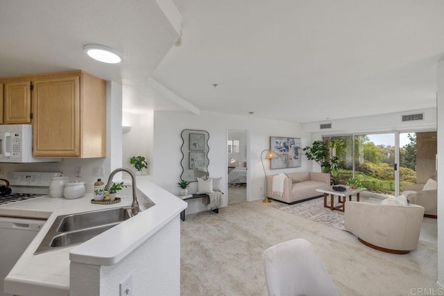 kitchen featuring tile countertops, light colored carpet, white appliances, a sink, and open floor plan