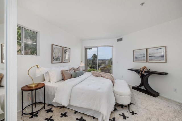 carpeted bedroom with access to outside, visible vents, and baseboards