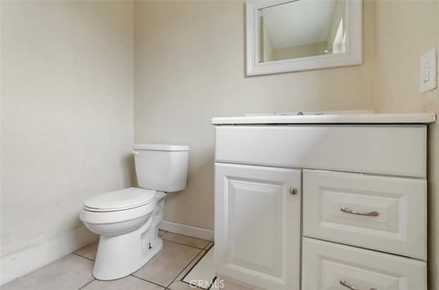 half bathroom featuring baseboards, vanity, toilet, and tile patterned floors