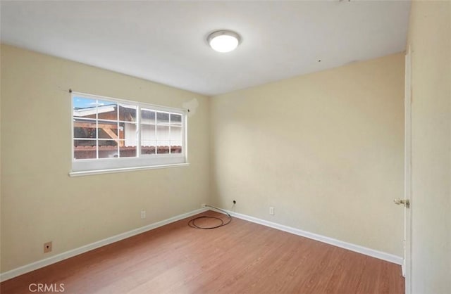 unfurnished room with wood finished floors and baseboards