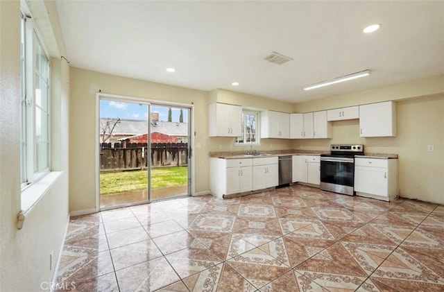 kitchen featuring stainless steel appliances, recessed lighting, visible vents, white cabinetry, and a sink