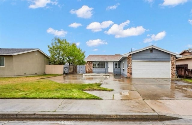 ranch-style house featuring driveway, stone siding, an attached garage, fence, and a front lawn