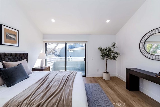 bedroom with baseboards, recessed lighting, wood finished floors, and access to exterior