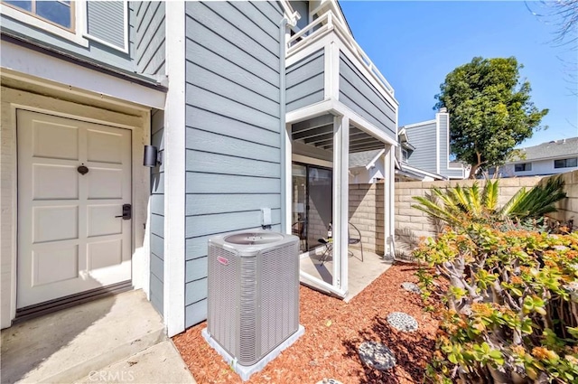 view of exterior entry with fence and cooling unit