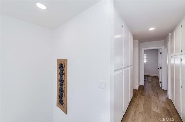 hallway featuring recessed lighting, baseboards, and light wood finished floors