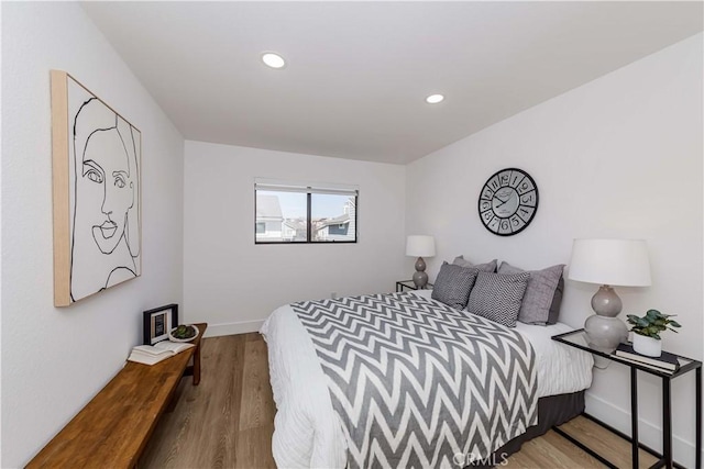 bedroom featuring baseboards, wood finished floors, and recessed lighting