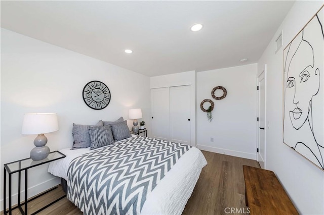 bedroom with a closet, visible vents, wood finished floors, and recessed lighting