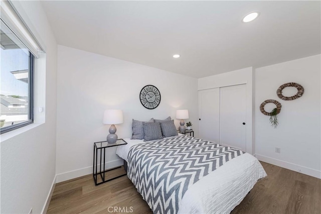 bedroom featuring a closet, baseboards, wood finished floors, and recessed lighting