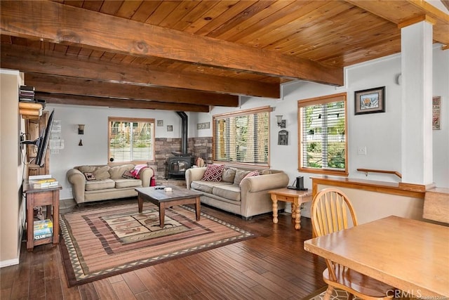 living area featuring beam ceiling, wood ceiling, dark wood finished floors, and a wood stove