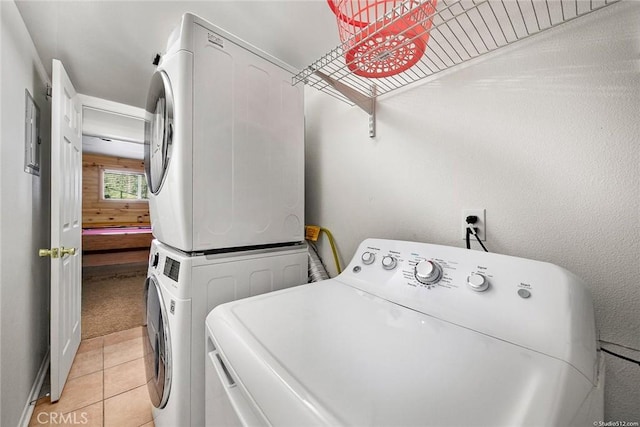 washroom with laundry area, light tile patterned floors, and stacked washing maching and dryer