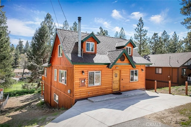 chalet / cabin featuring roof with shingles