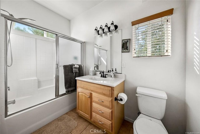 full bath featuring tile patterned flooring, toilet, vanity, and bath / shower combo with glass door