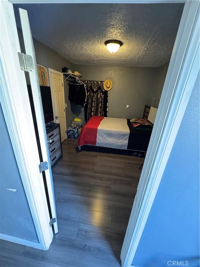 bedroom featuring wood finished floors and a textured ceiling