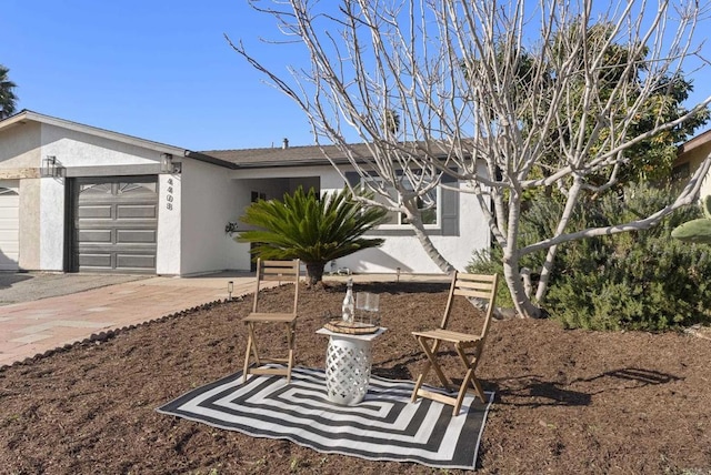 view of front of property with a garage, driveway, and stucco siding