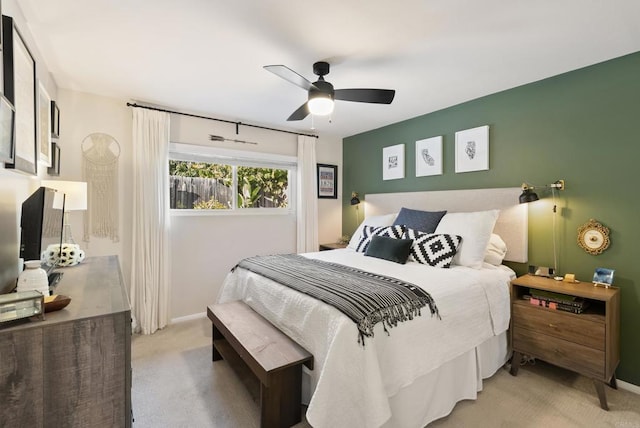 bedroom with light colored carpet, baseboards, and ceiling fan