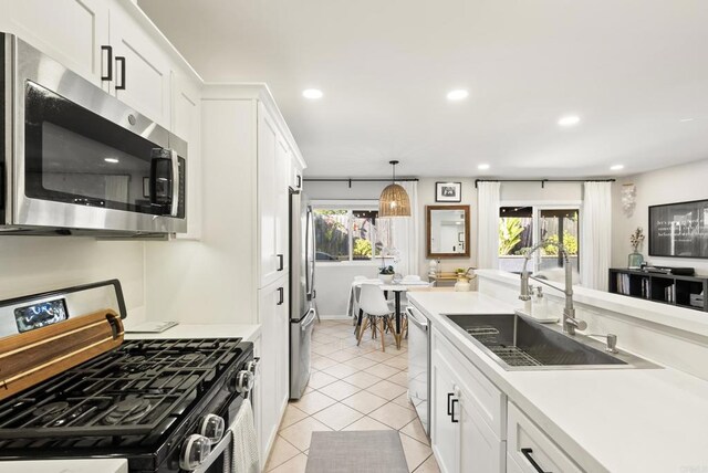 kitchen with light countertops, recessed lighting, light tile patterned flooring, stainless steel appliances, and a sink