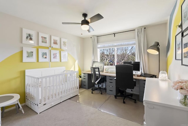 bedroom featuring a crib, carpet floors, and a ceiling fan