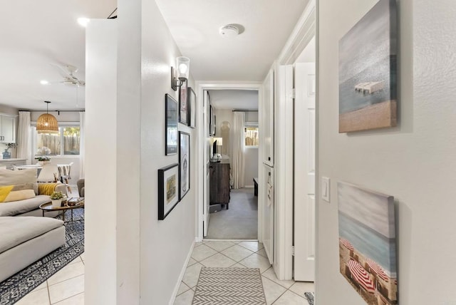 hallway featuring light tile patterned flooring and baseboards