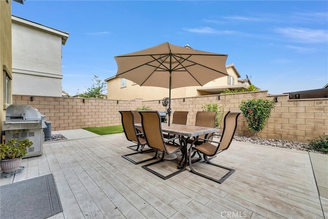 view of patio / terrace featuring outdoor dining space, a fenced backyard, a wooden deck, and area for grilling