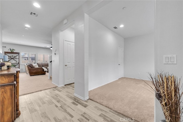 interior space with recessed lighting, light colored carpet, visible vents, and light wood-style floors