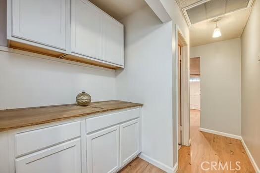 interior space featuring light wood-type flooring, visible vents, and baseboards