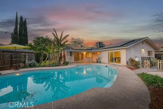 view of swimming pool featuring a patio area, fence, a fenced in pool, and central air condition unit