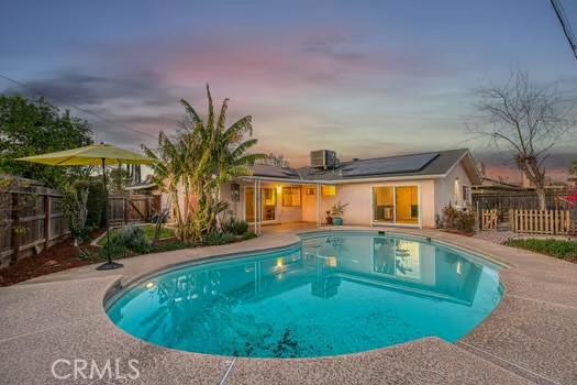 pool at dusk featuring a fenced in pool, cooling unit, a patio area, and a fenced backyard