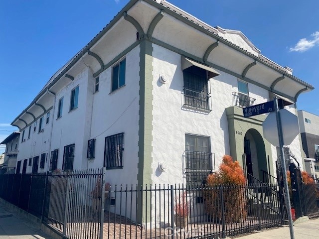 view of property exterior with fence and stucco siding