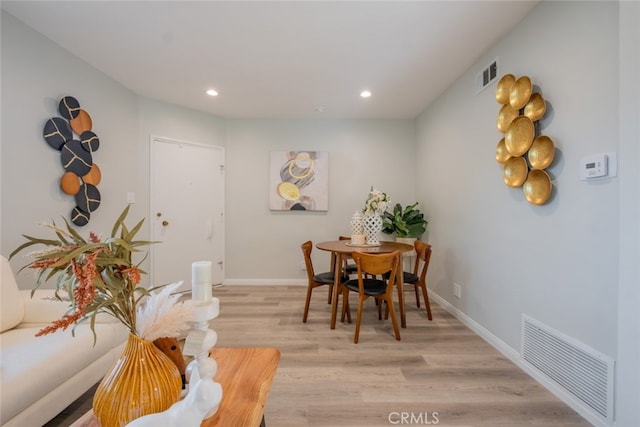 dining space with light wood-type flooring, visible vents, and recessed lighting