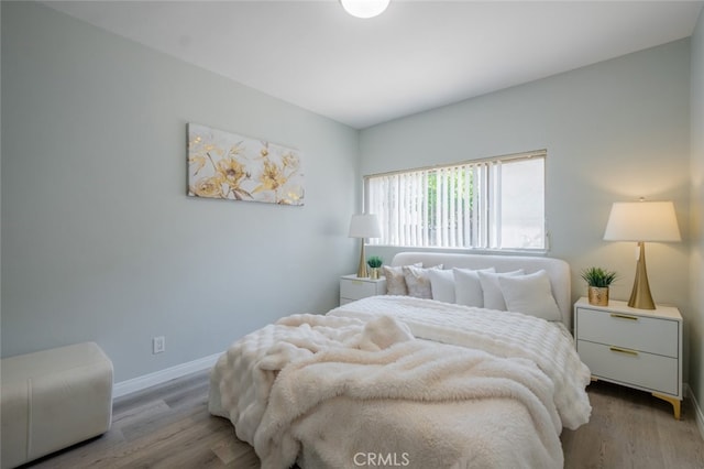 bedroom with baseboards and wood finished floors