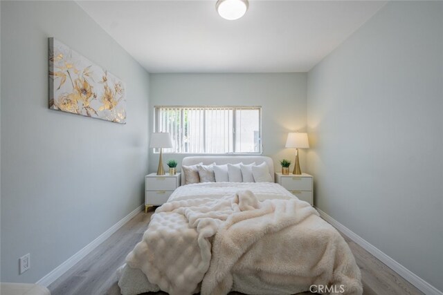 bedroom with baseboards and wood finished floors