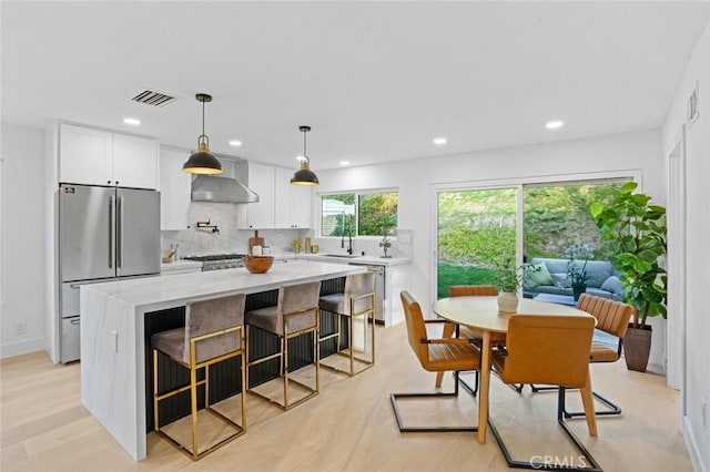 kitchen featuring visible vents, a sink, tasteful backsplash, stainless steel appliances, and white cabinets