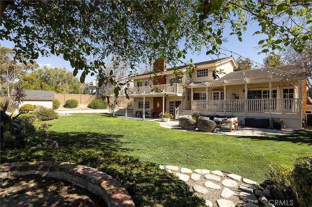 back of property with a wooden deck, a patio, fence, a yard, and outdoor lounge area