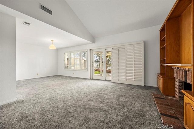 living area featuring lofted ceiling, dark colored carpet, a brick fireplace, and visible vents