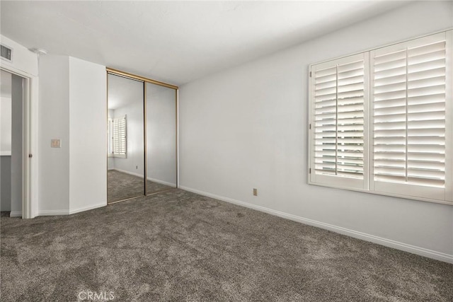 unfurnished bedroom featuring a closet, carpet flooring, visible vents, and baseboards