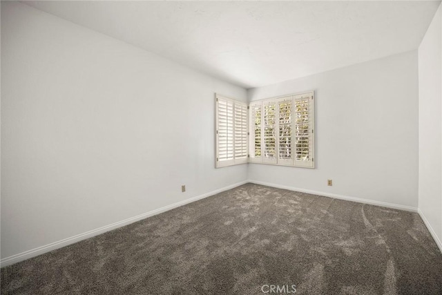 carpeted empty room with baseboards