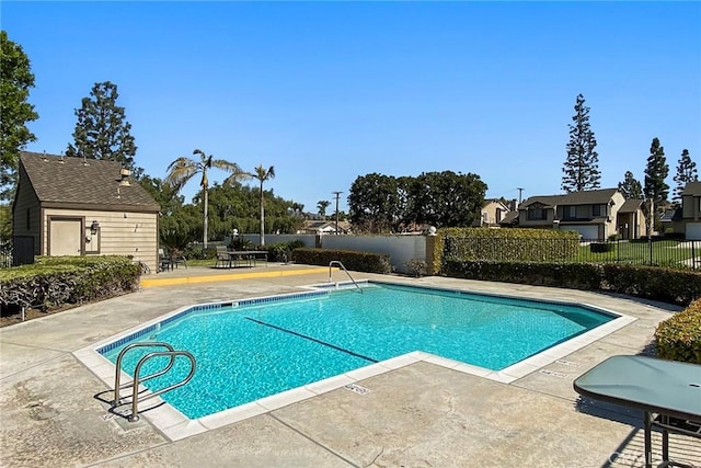 community pool with fence and a patio