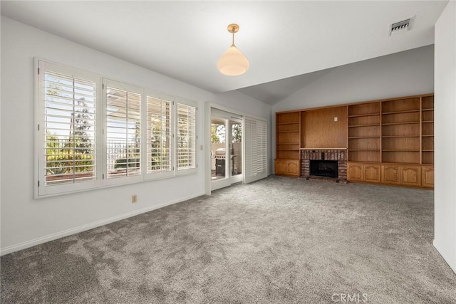 unfurnished living room with vaulted ceiling, a brick fireplace, carpet flooring, and visible vents