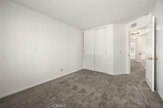 unfurnished bedroom with carpet floors, a closet, visible vents, and baseboards