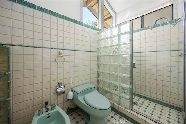 bathroom with a walk in shower, toilet, a bidet, and tile walls